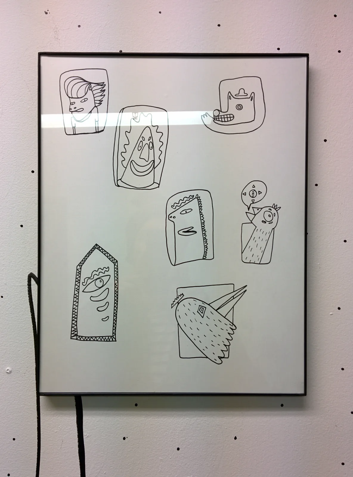 Cadre réunissant sept petites têtes dessinées au trait — visages, oiseaux, museau —, chacune dans son propre encadré, posées librement sur la page